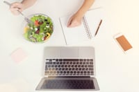 employee eating salad at their desk